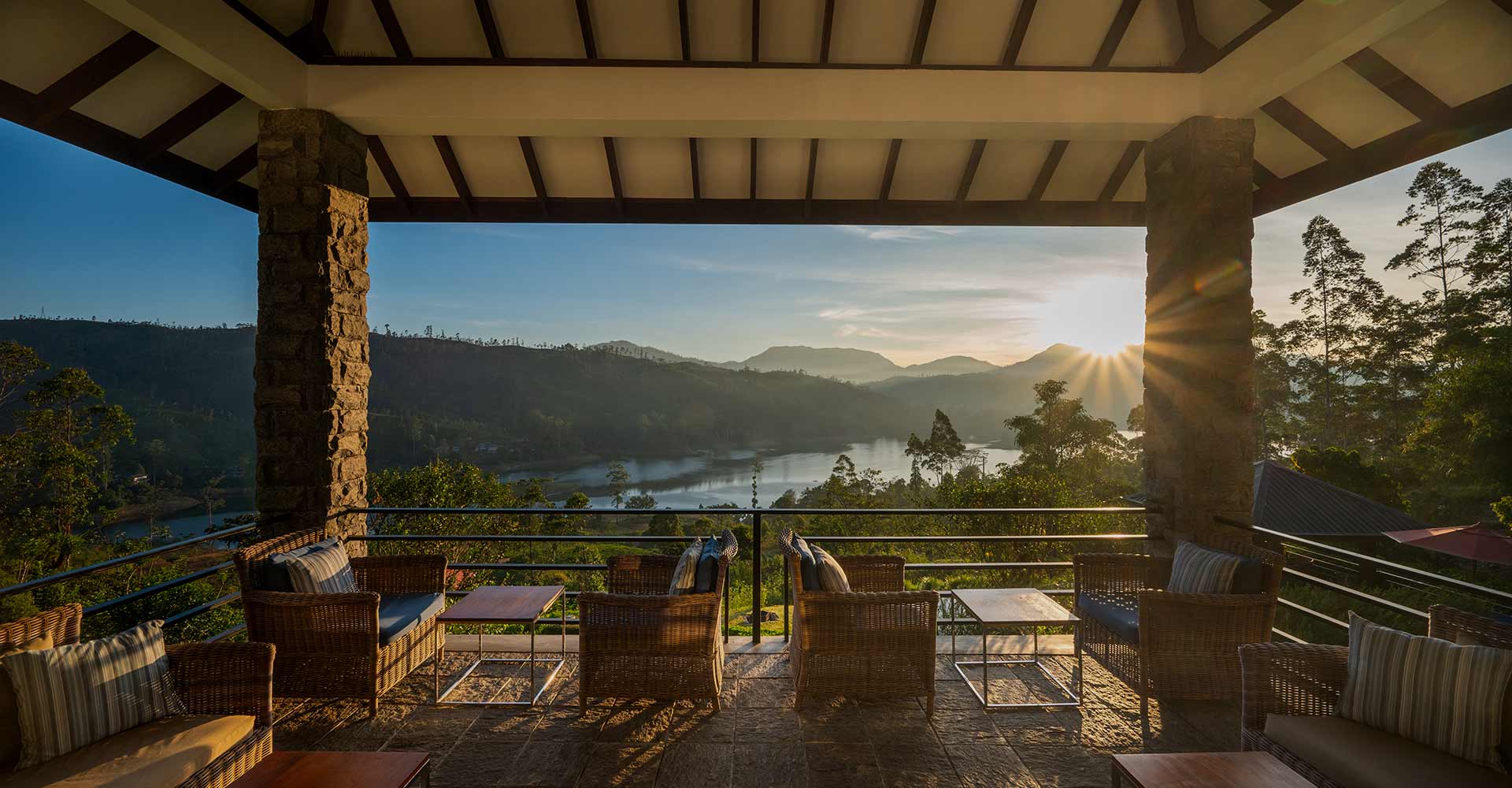 Camellia Hills, a luxury tea bungalow in Hatton, Sri Lanka, with sunrise views of hills and a quiet lake from a seating area